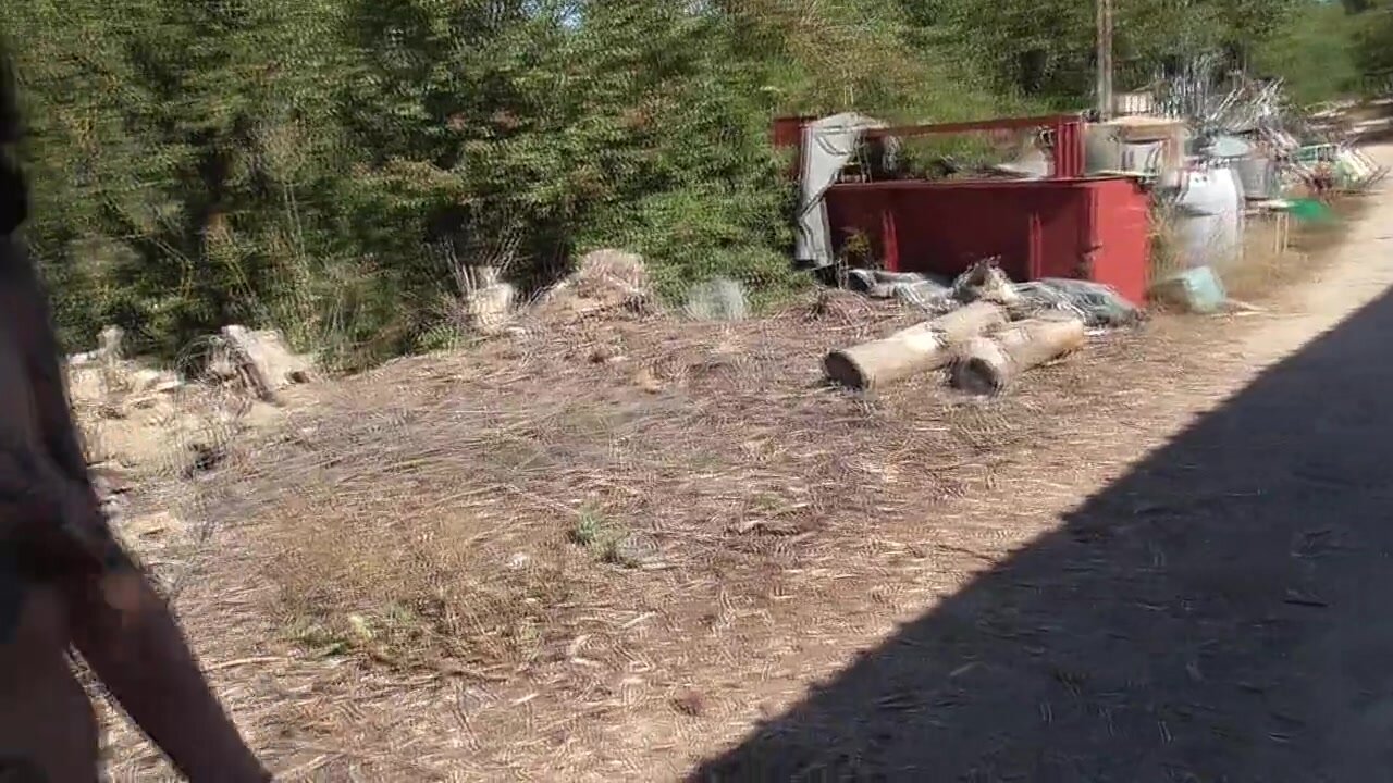Mujer nudista exhibicionista está caminando por la carretera cerca de la  playa